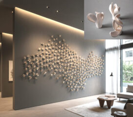 Dynamic abstract clay flowers arranged in a large wall installation in a hotel lobby.