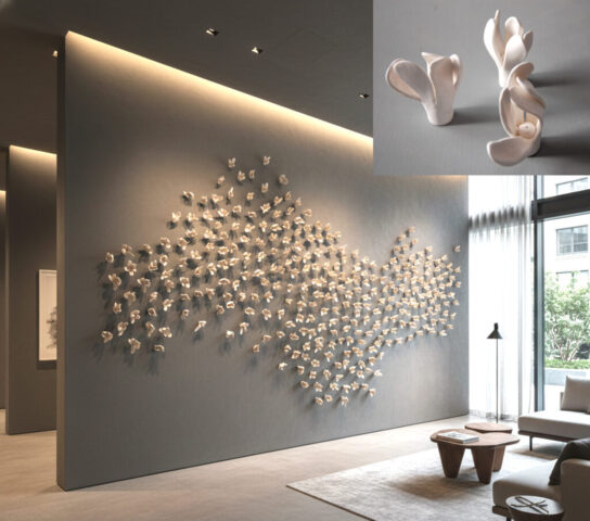 Dynamic abstract clay flowers arranged in a large wall installation in a hotel lobby.