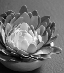 closeup view of hand-sculpted clay dimensional flower in gray and white forming part of an art installation
