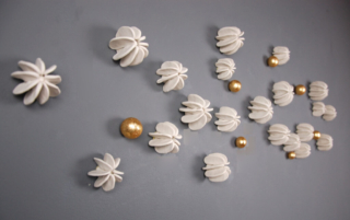 abstract modern organic sculpture wall installation in off-white and gold leaf, inspired by carambola star fruit. Fabulous dimensional 3d wall art for interior design projects, hotels or public spaces. Commissioned art.