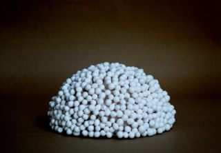 half ball shaped white sculpture inspired by enoki mushrooms, highly tactile and textured artwork for interior design.