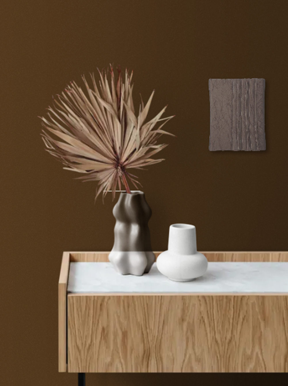 Rectangular, deep brown crinkled taffeta fabric wall art, 'Rhythm,' featuring lines of hand-stitching, stands on a white surface beside a light-colored pot with a blue-green succulent, against a brown wall.
